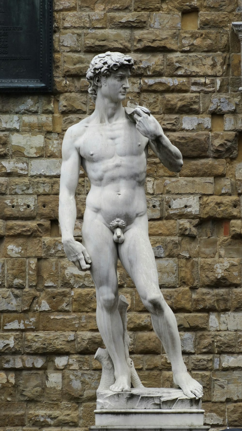 statue of man holding book