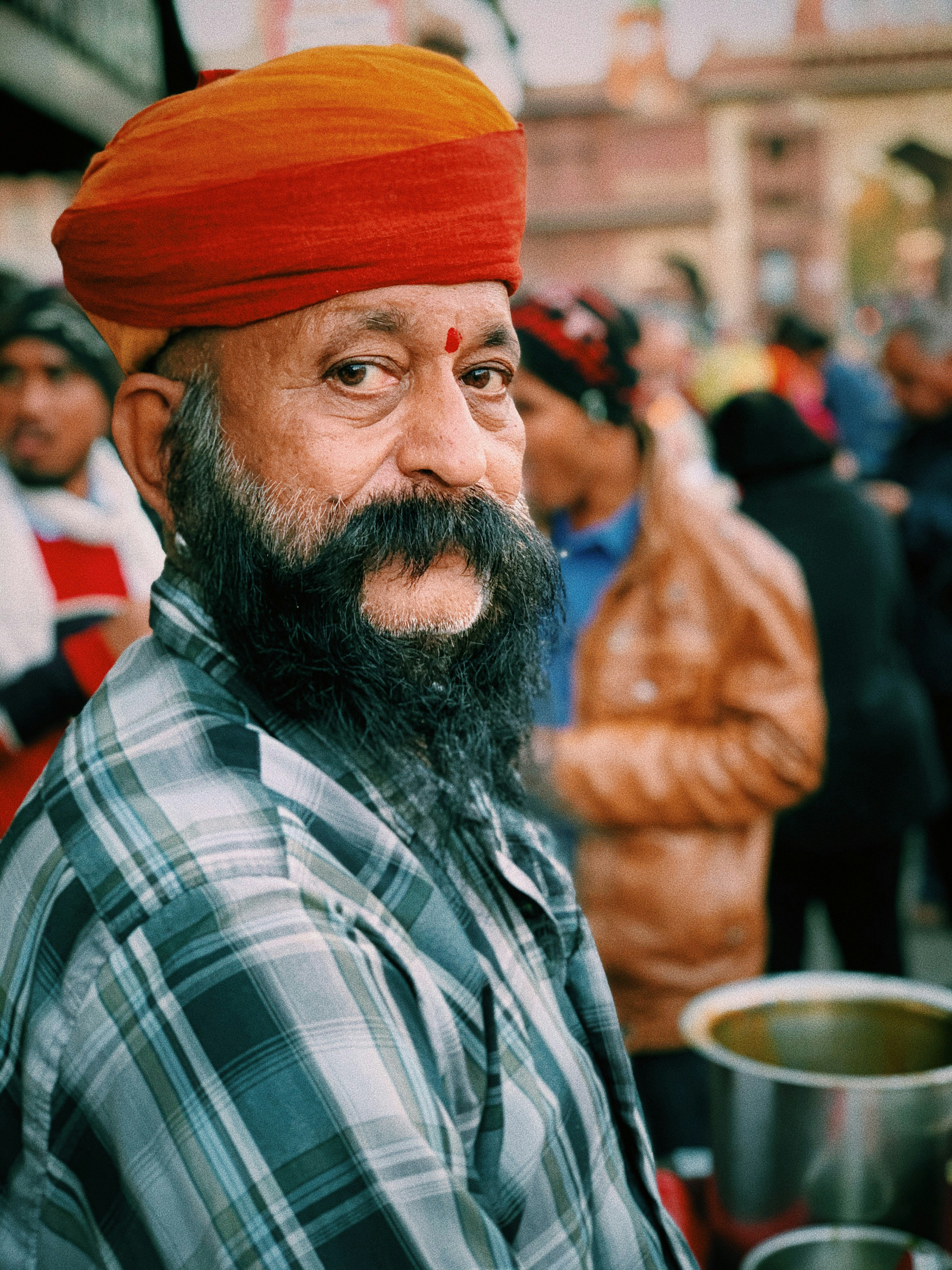 man in red and white plaid dress shirt wearing orange knit cap