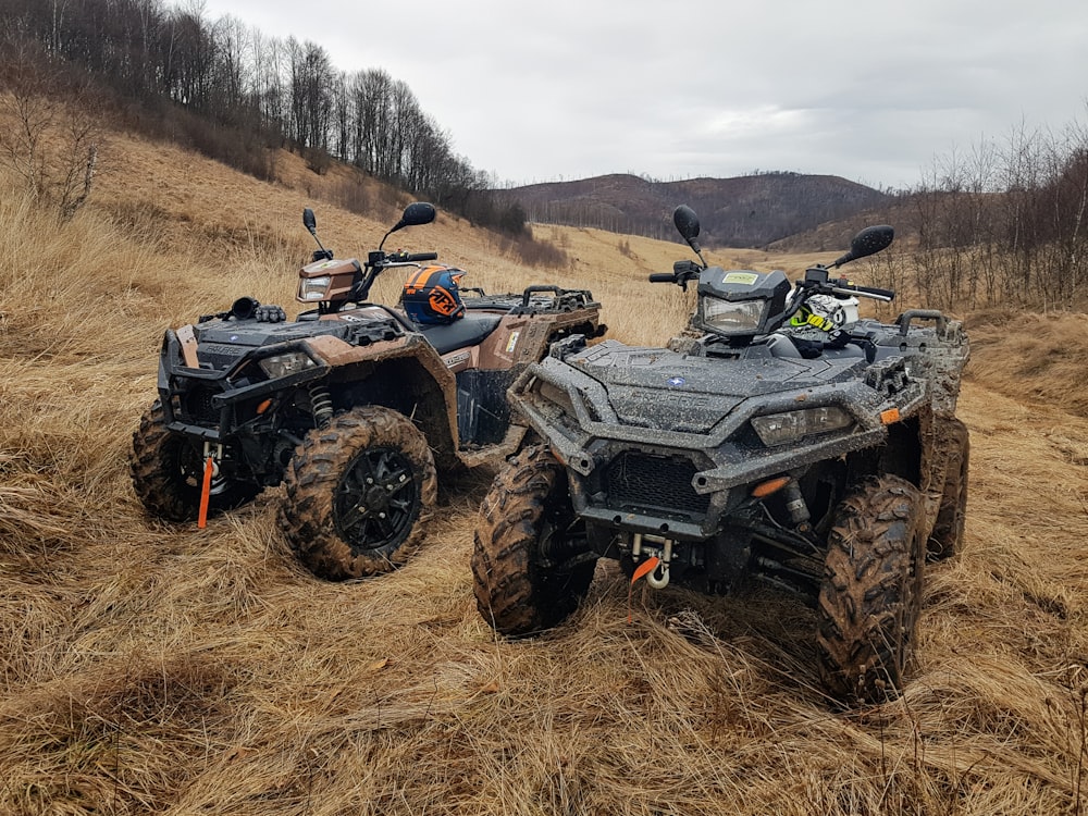 日中の茶色のフィールドに黒と灰色のATV