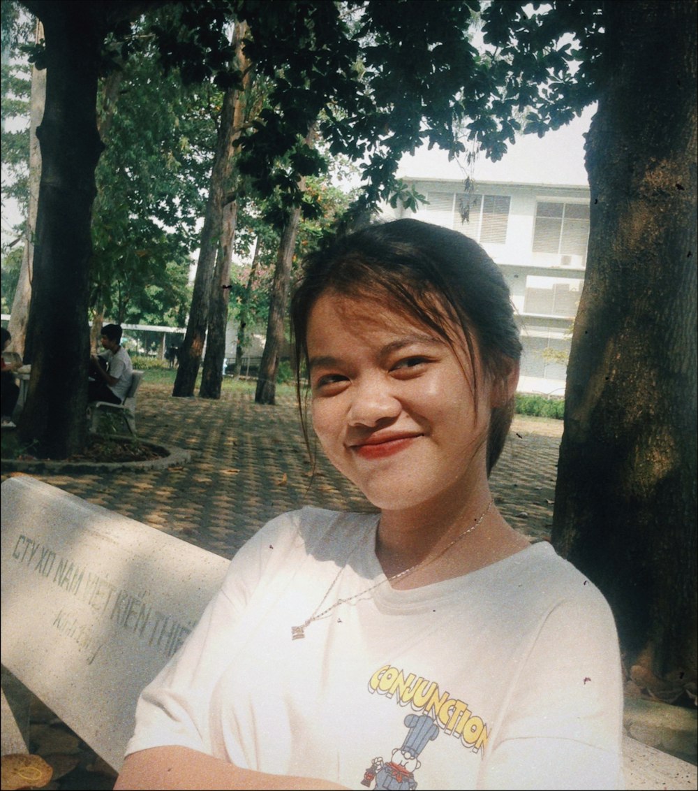 woman in white crew neck t-shirt sitting on bench