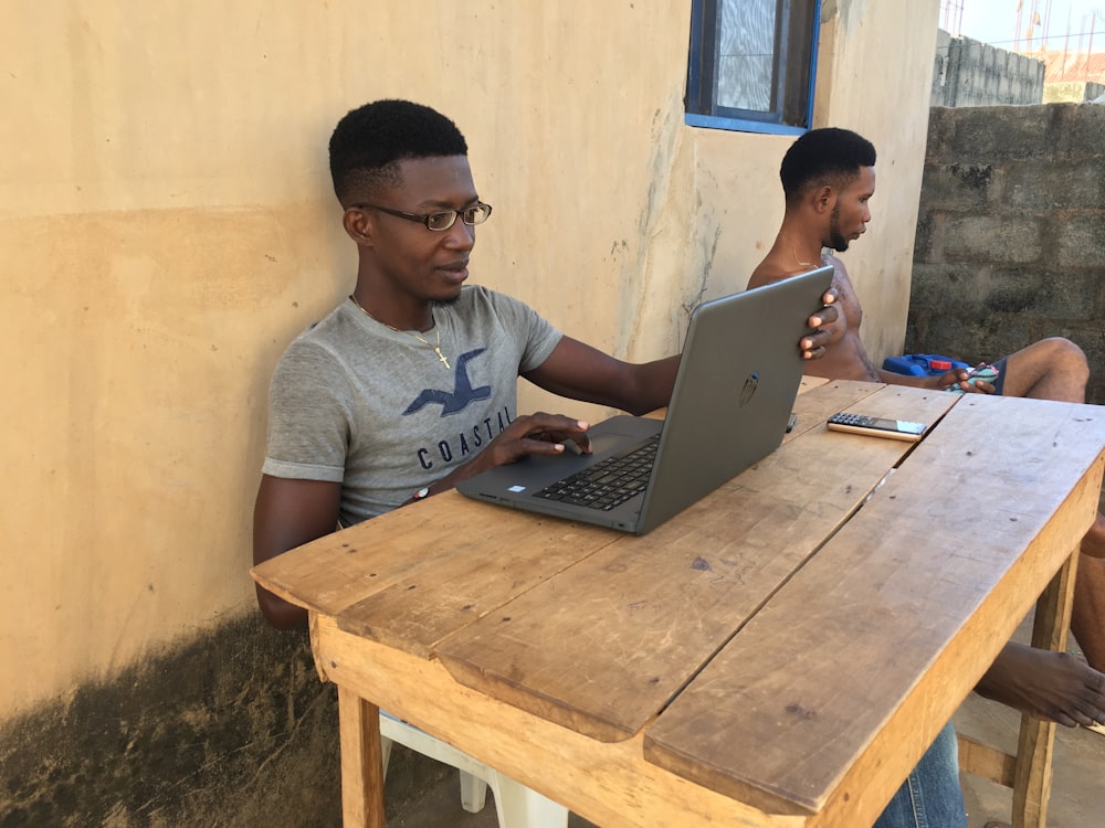 man in gray crew neck t-shirt using macbook pro