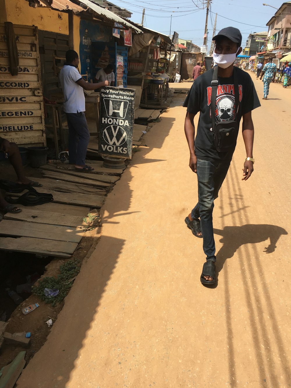 man in black crew neck t-shirt and gray pants standing on brown concrete floor during