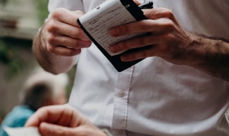 man in white button up shirt holding black and white box