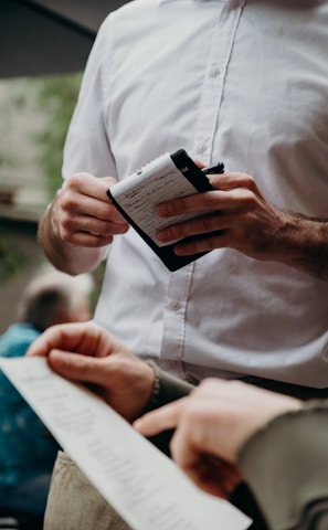 man in white button up shirt holding black and white box