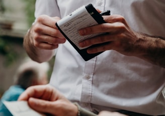 man in white button up shirt holding black and white box