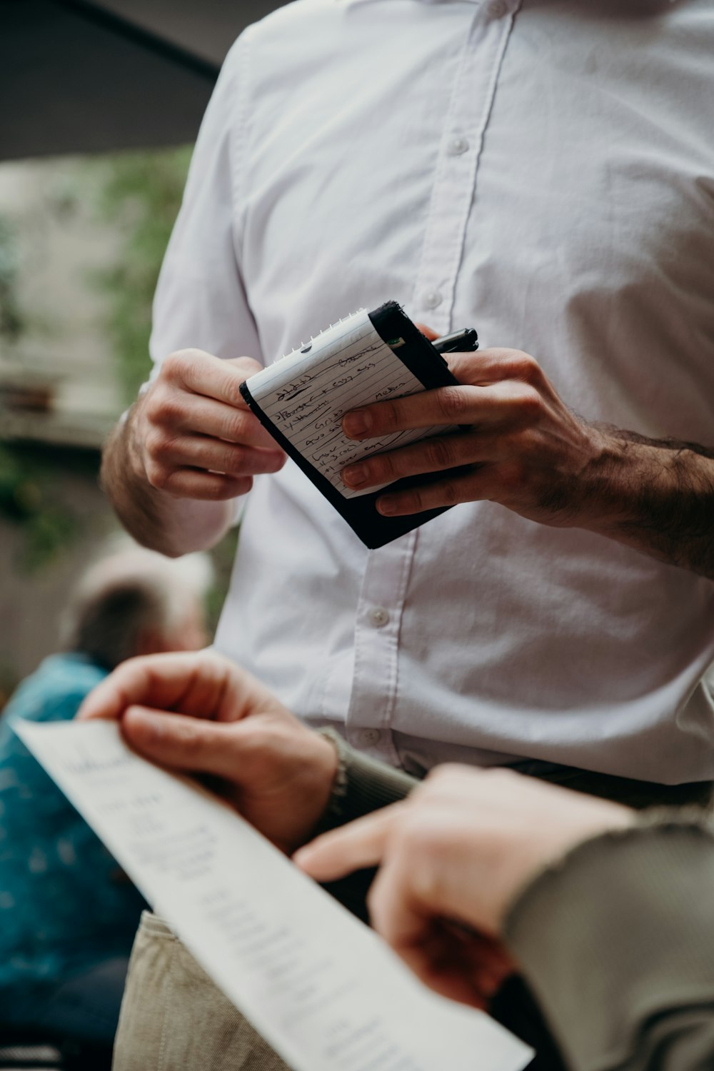 man in white button up shirt holding black and white box