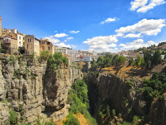 white concrete building on top of mountain during daytime in Constantine Algeria