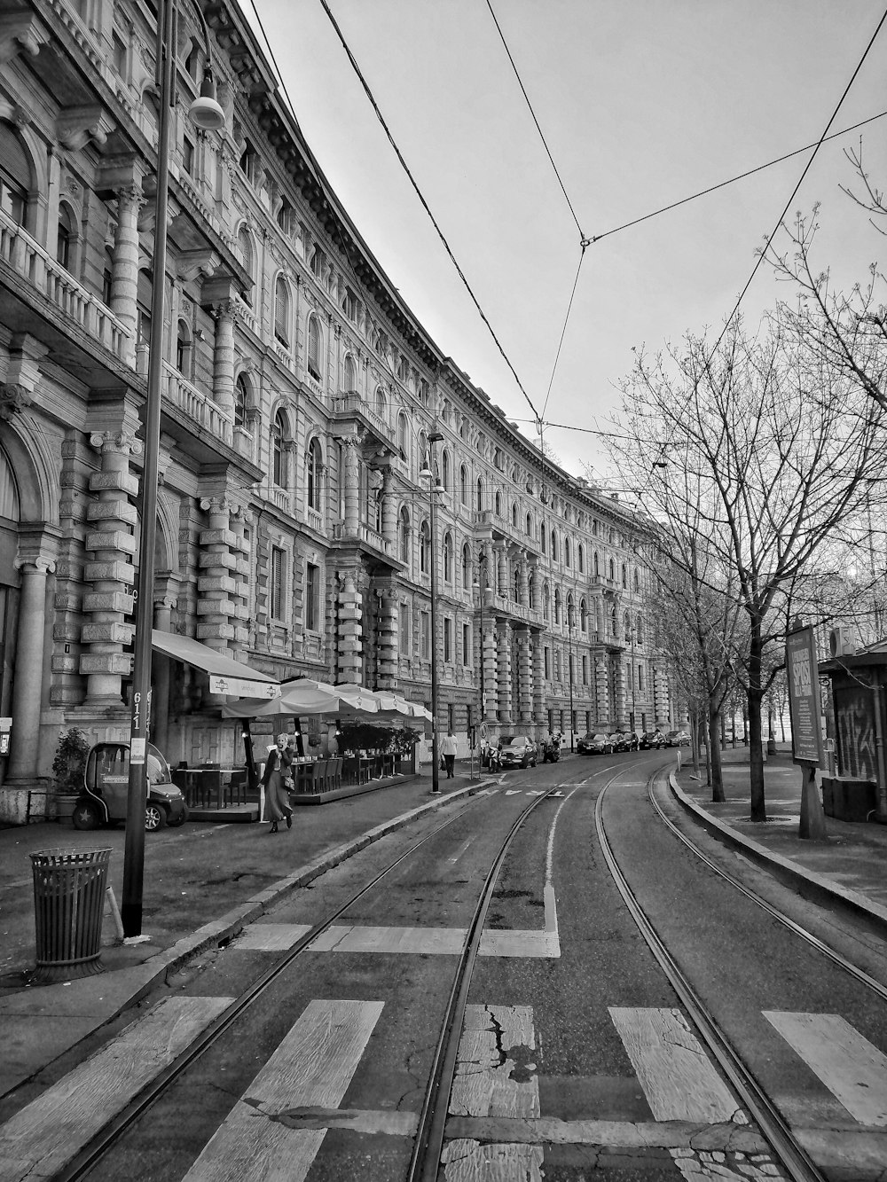 grayscale photo of people walking on street near building