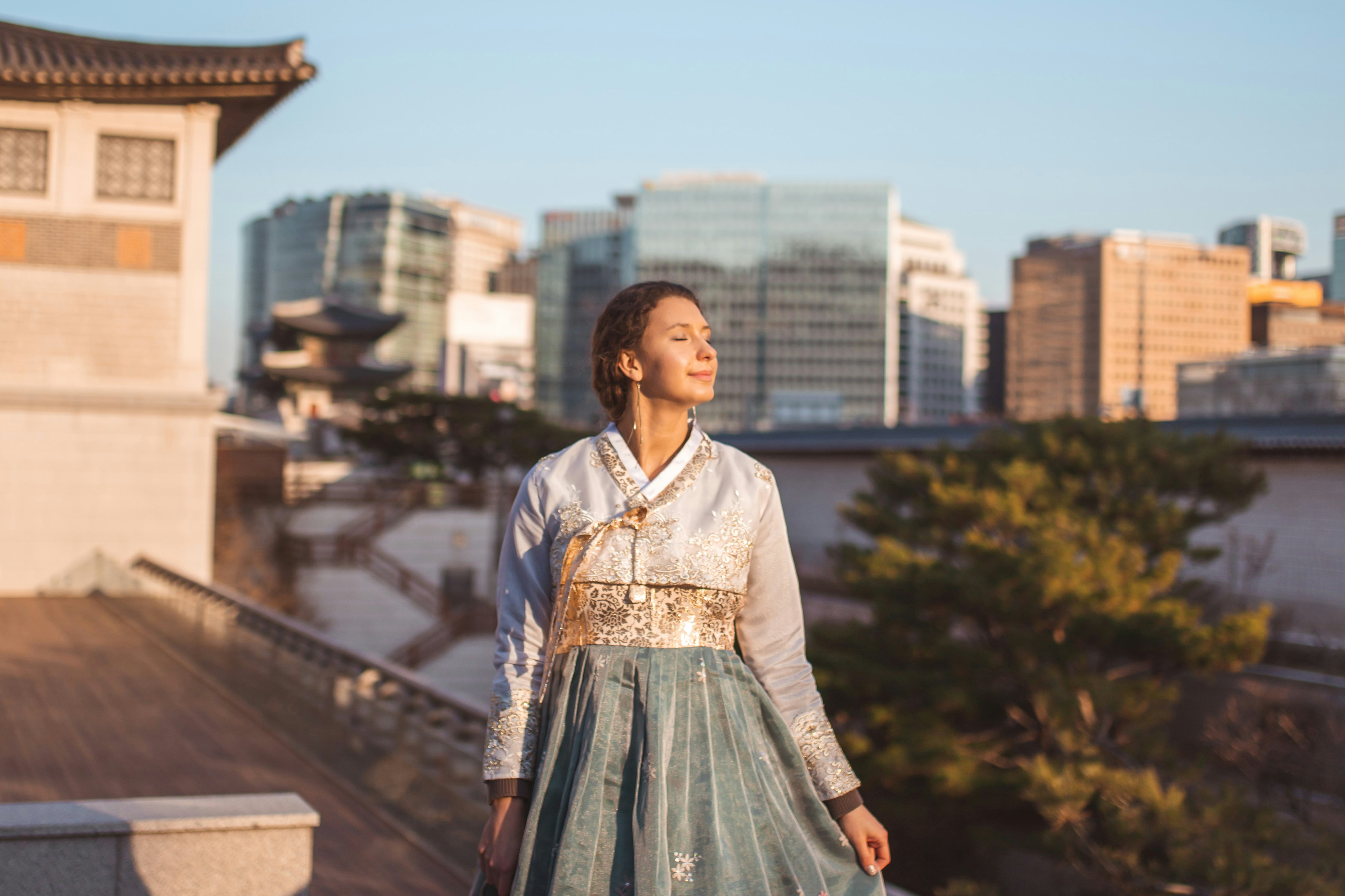woman in white and blue dress standing on brown wooden bridge during daytime