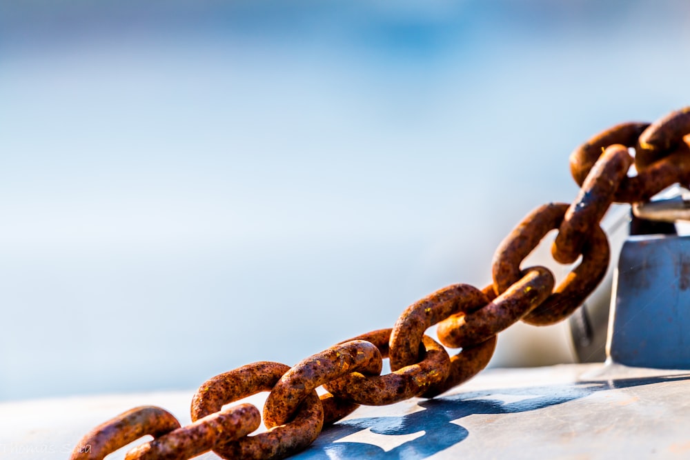 brown metal chain on white wooden surface