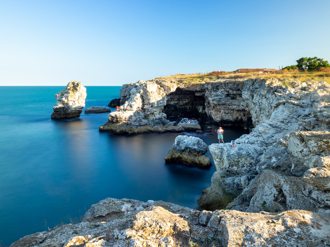 brown rock formation on blue sea under blue sky during daytime