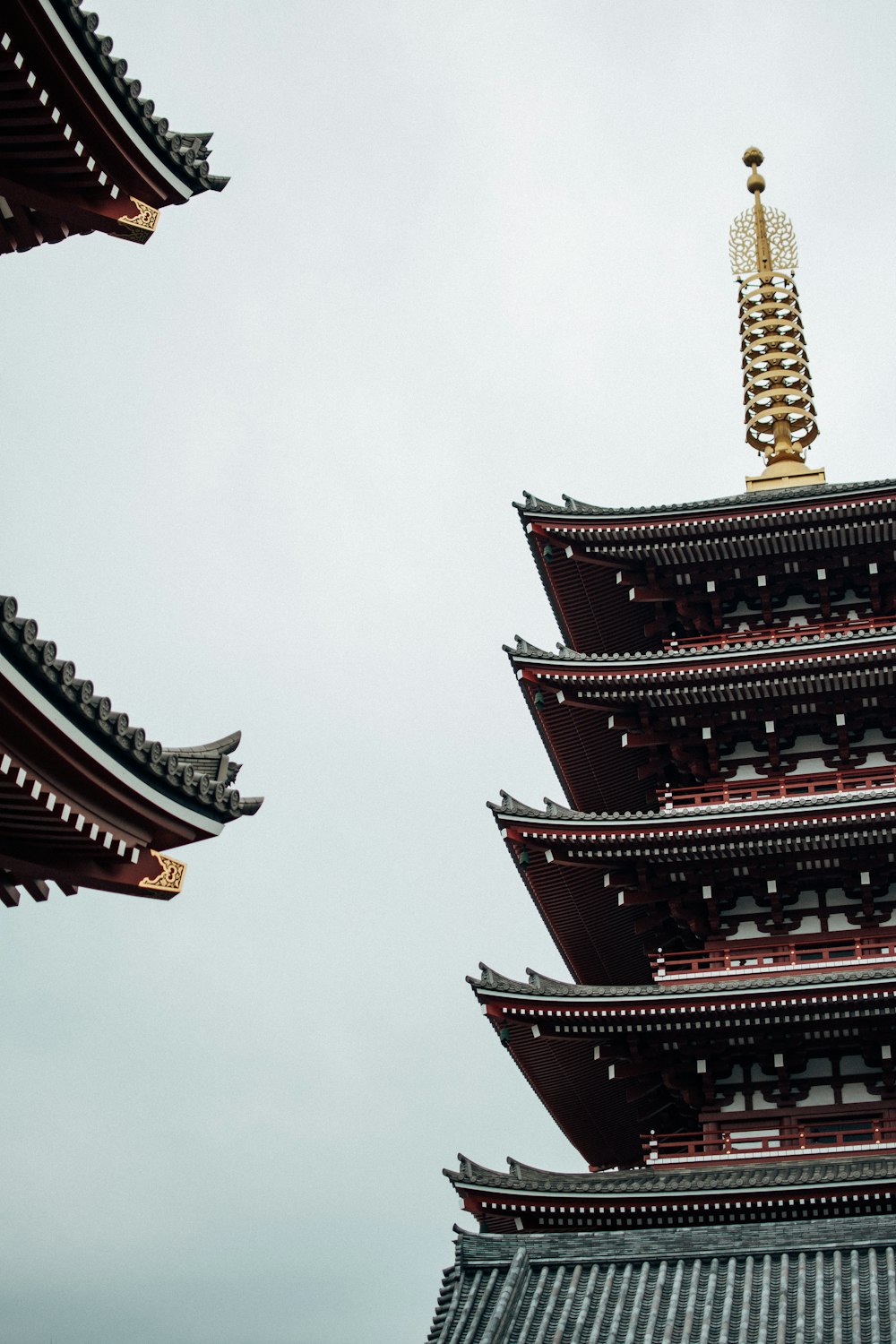 gold and red tower under white sky