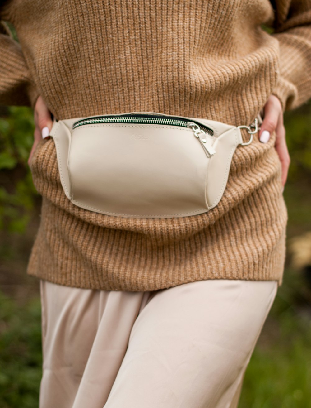 woman in brown knit sweater and white pants