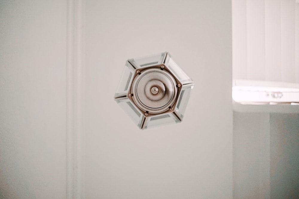 silver round ornament on white surface