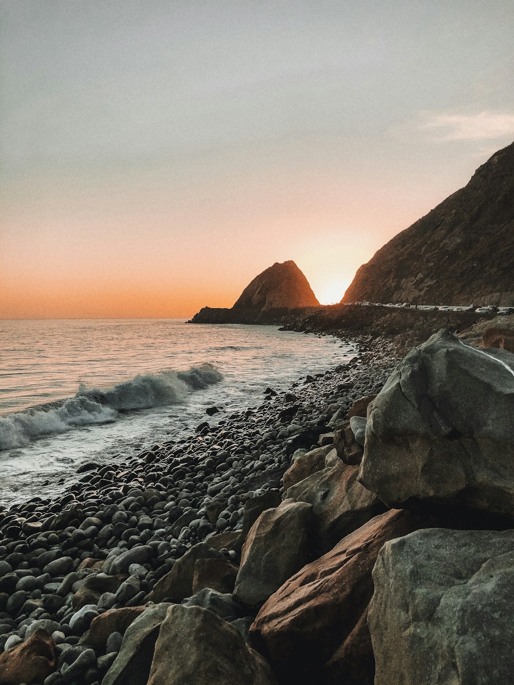 brown rocky shore near body of water during daytime