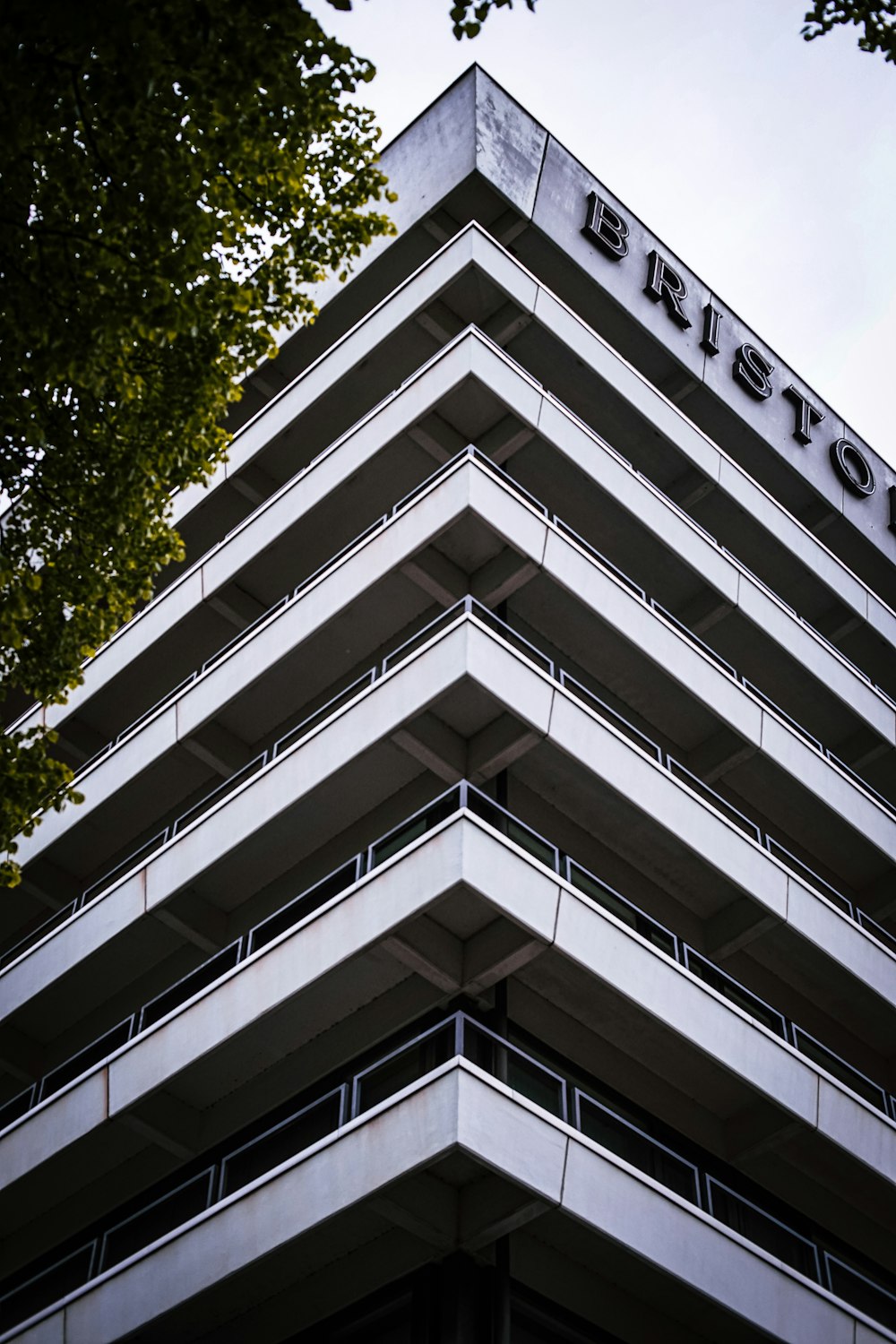 white concrete building near green tree during daytime