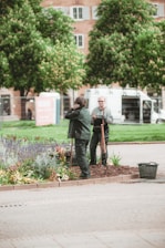 man in black jacket and pants standing on sidewalk during daytime
