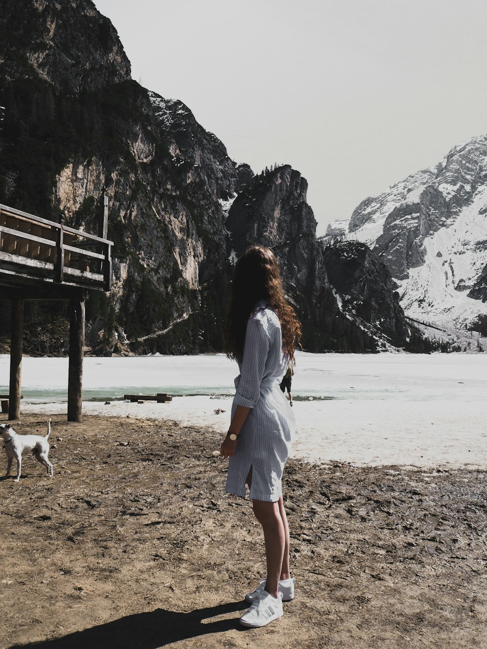낮 동안 해변을 걷고 있는 하얀 드레스를 입은 여자