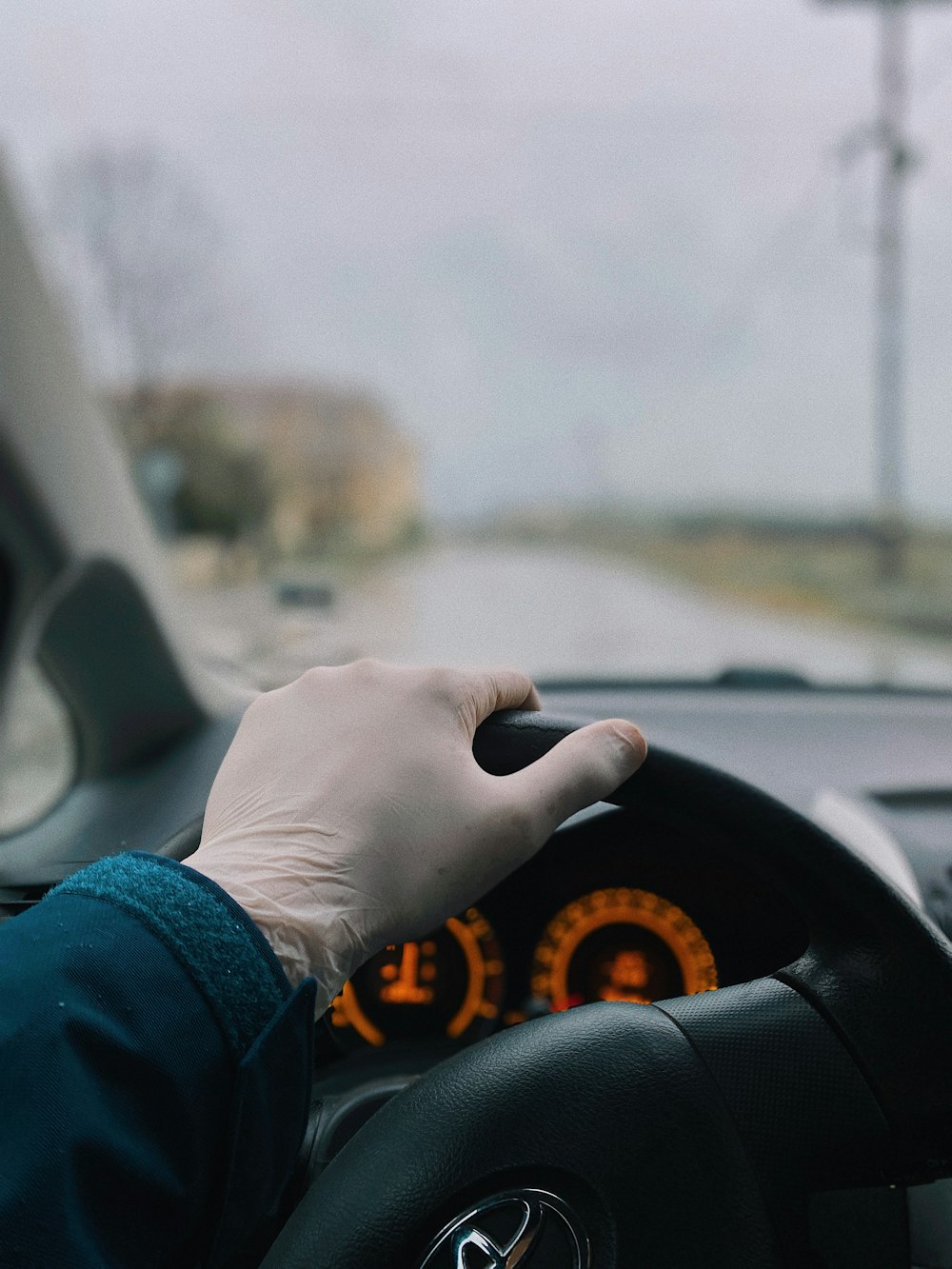 Persona con camisa azul de manga larga conduciendo un automóvil durante el día