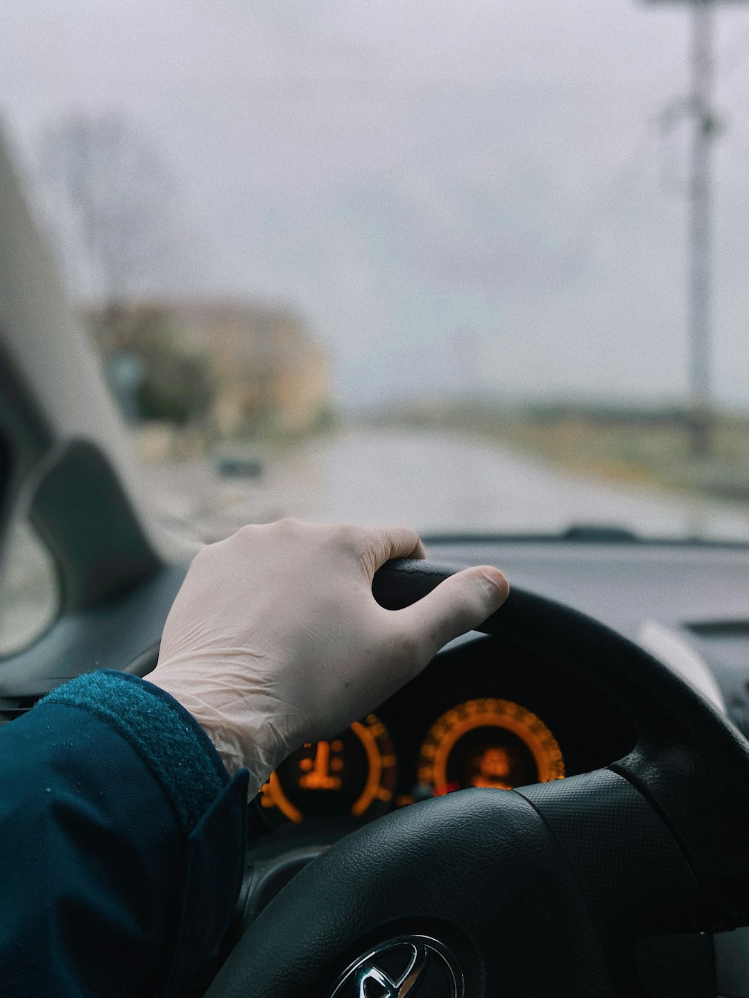 person in blue long sleeve shirt driving car during daytime