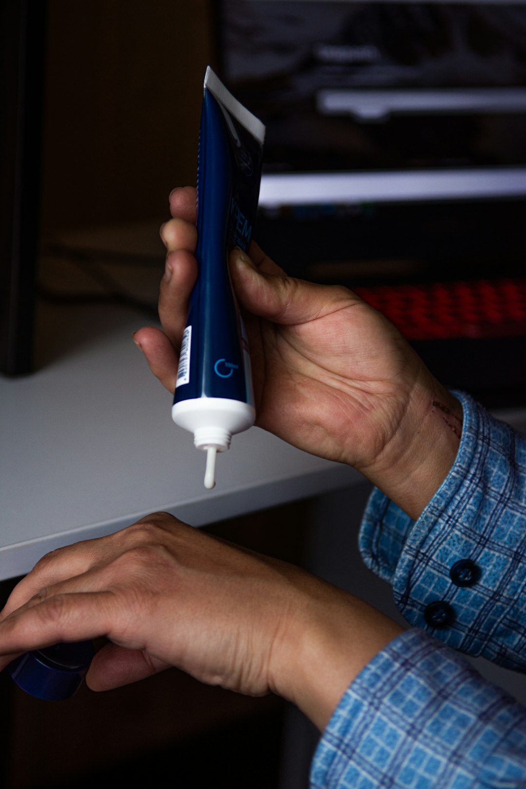 person holding blue and white electric toothbrush