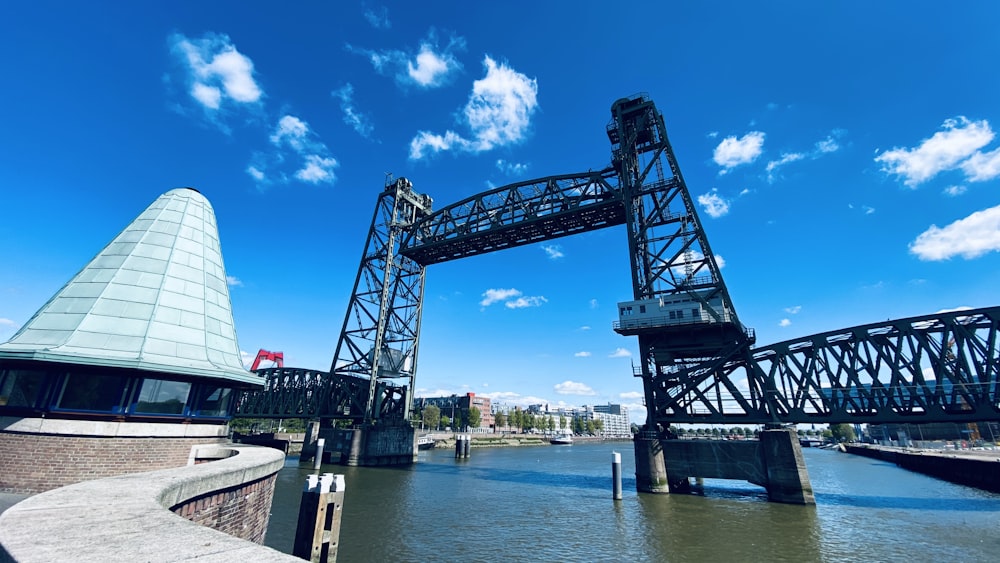 blue metal bridge over body of water during daytime