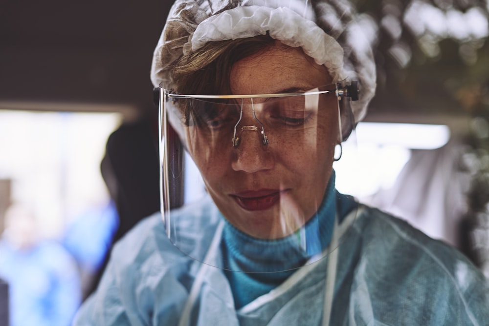 woman in teal scrub shirt wearing white head band