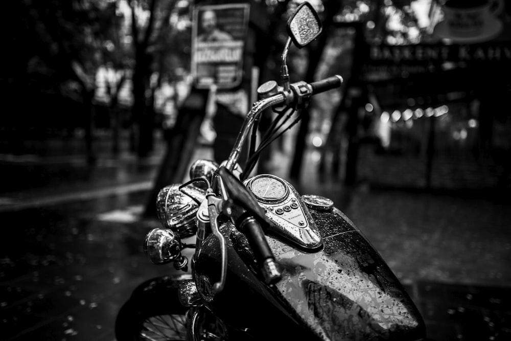 grayscale photo of motorcycle parked on sidewalk