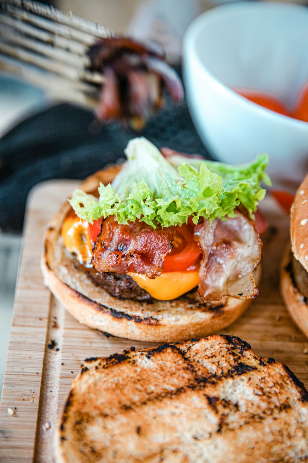 burger with lettuce and tomato on brown wooden chopping board