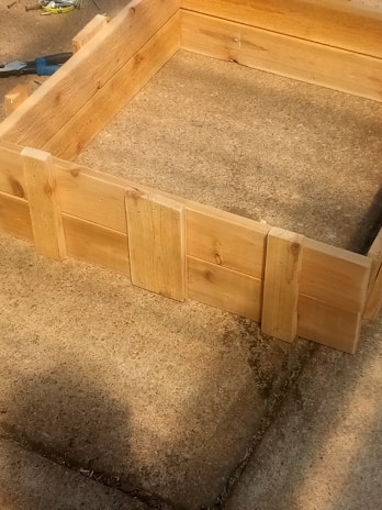 Close-up of a handcrafted wooden planter box with visible natural grain and smooth finish.