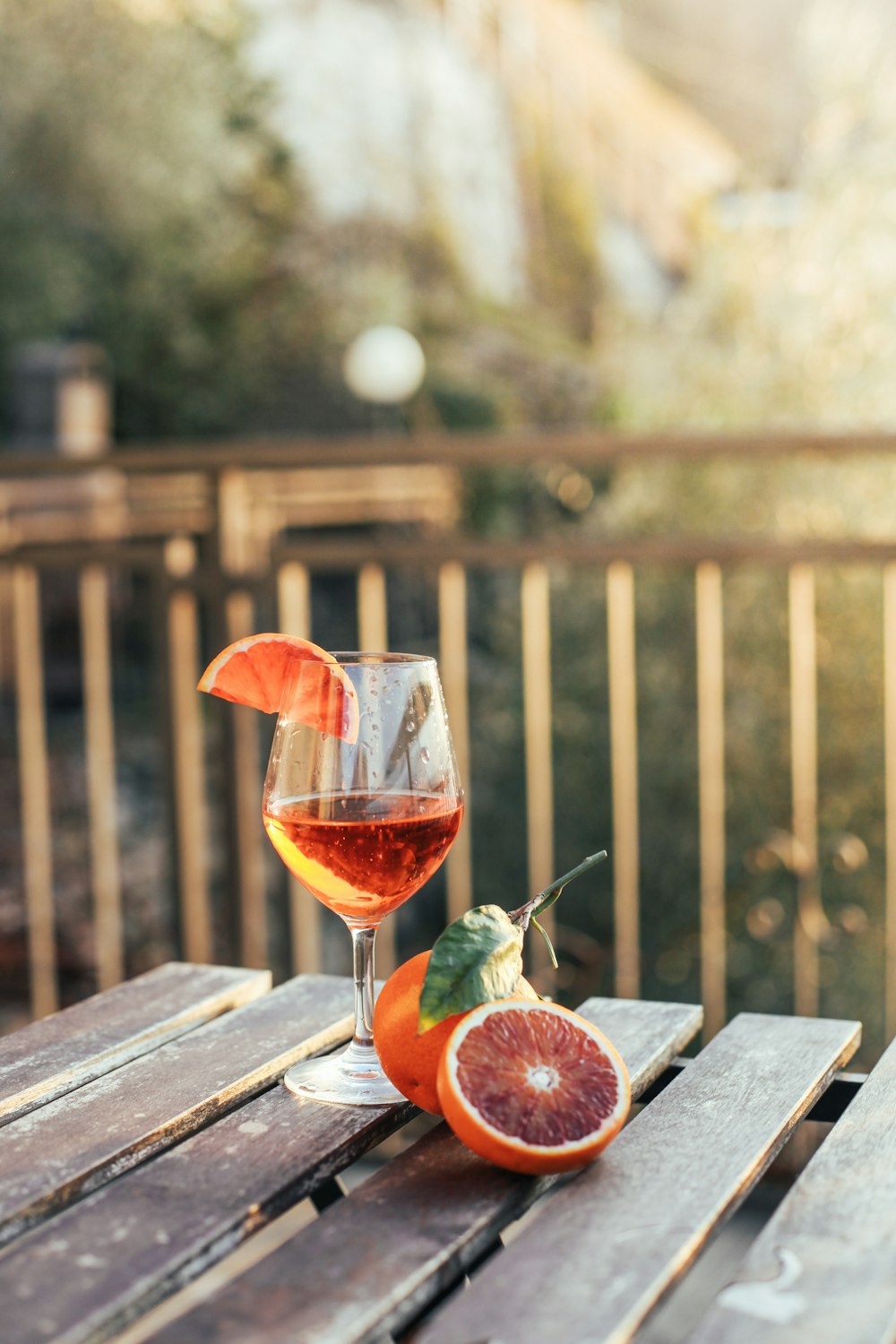Copa de vino transparente con líquido rojo sobre mesa de madera marrón