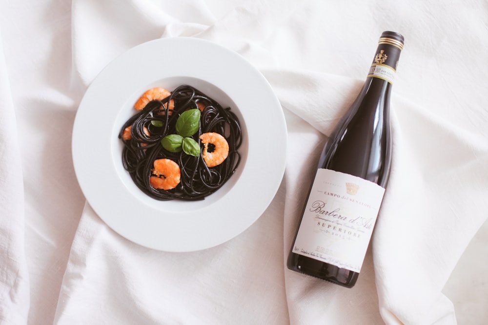 white ceramic plate with green vegetable and wine bottle