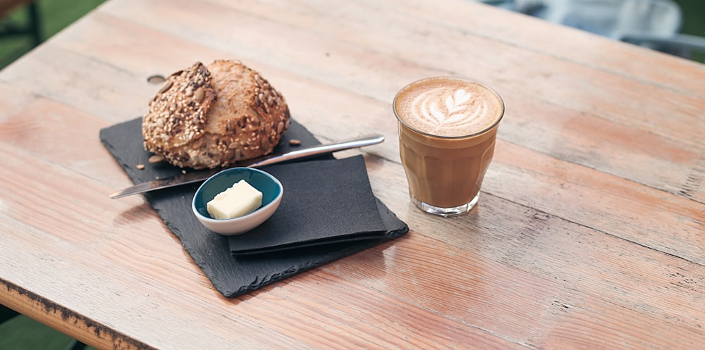 chocolate drink on white ceramic saucer beside chocolate cookies on brown wooden table