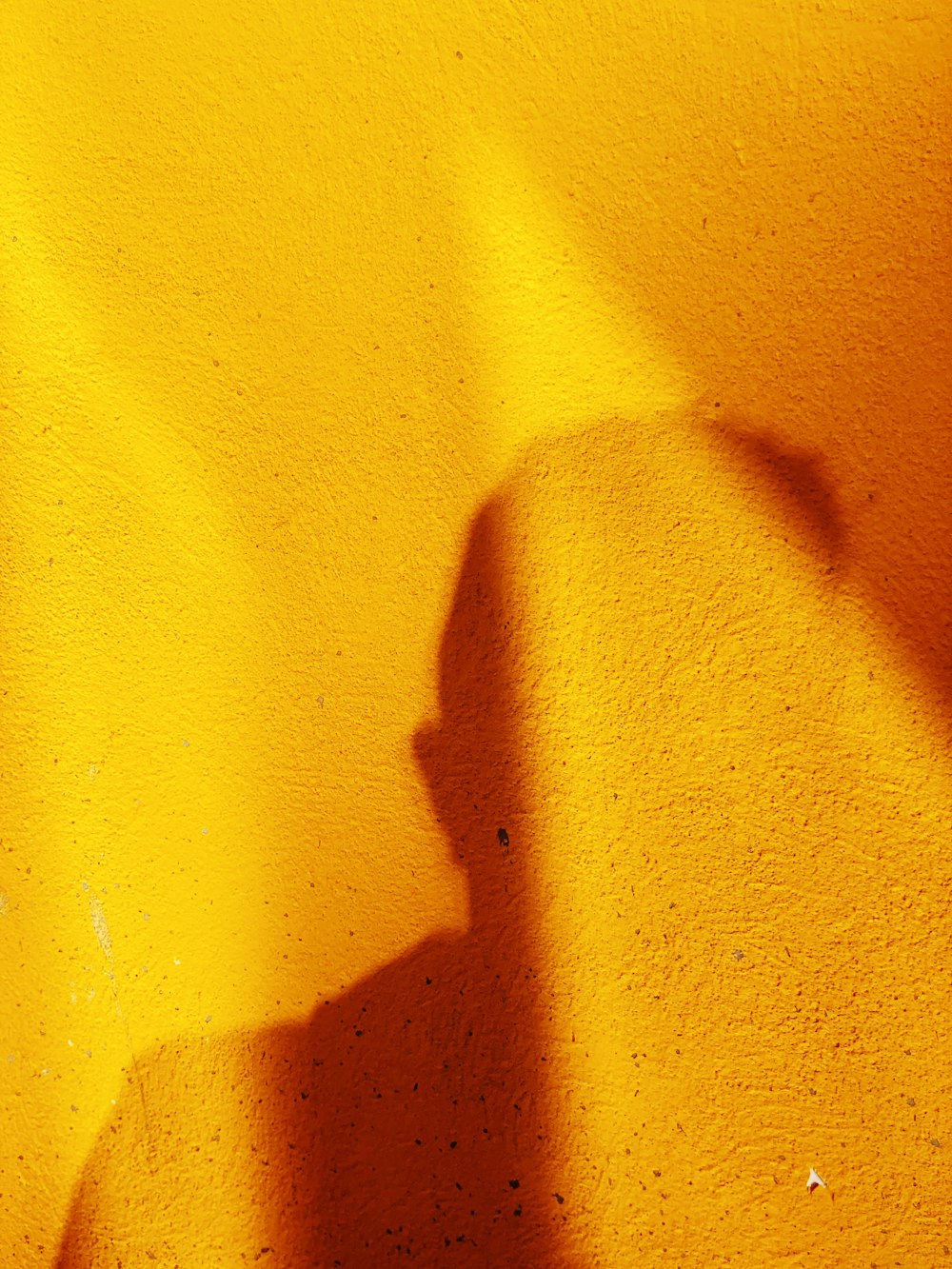 Schatten der Person auf gelber Wand