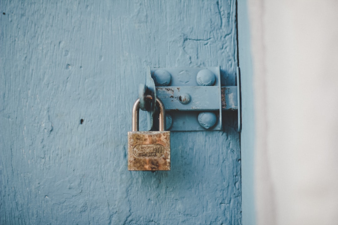  brown padlock on blue wooden door lock