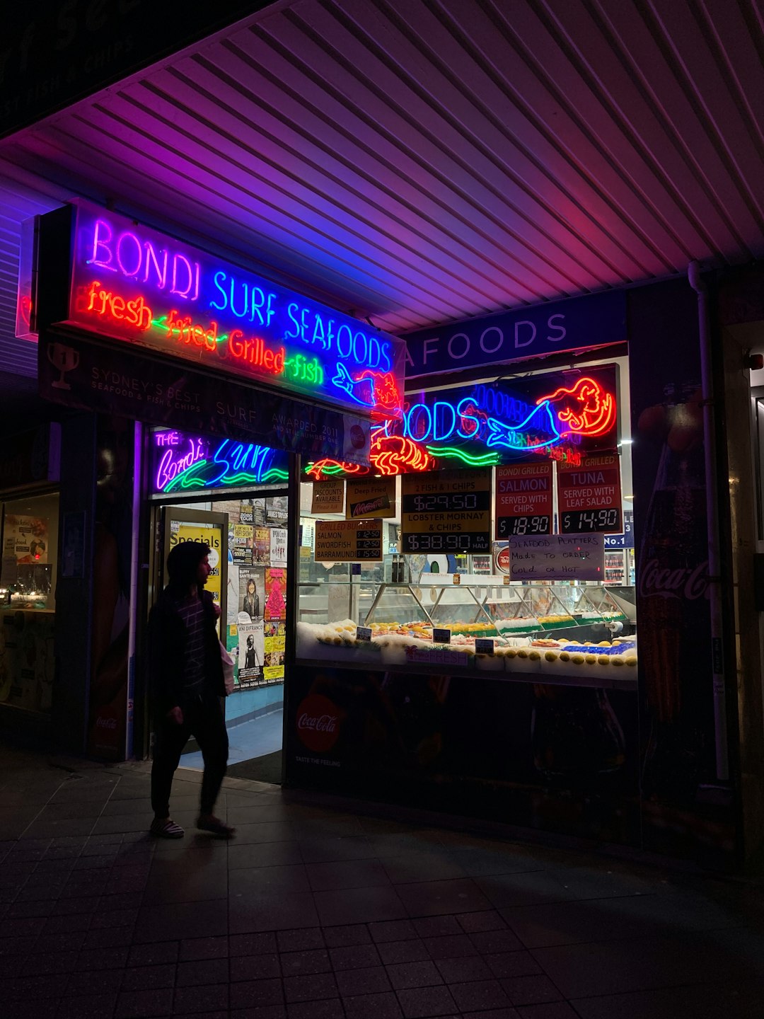 man in black jacket standing in front of store