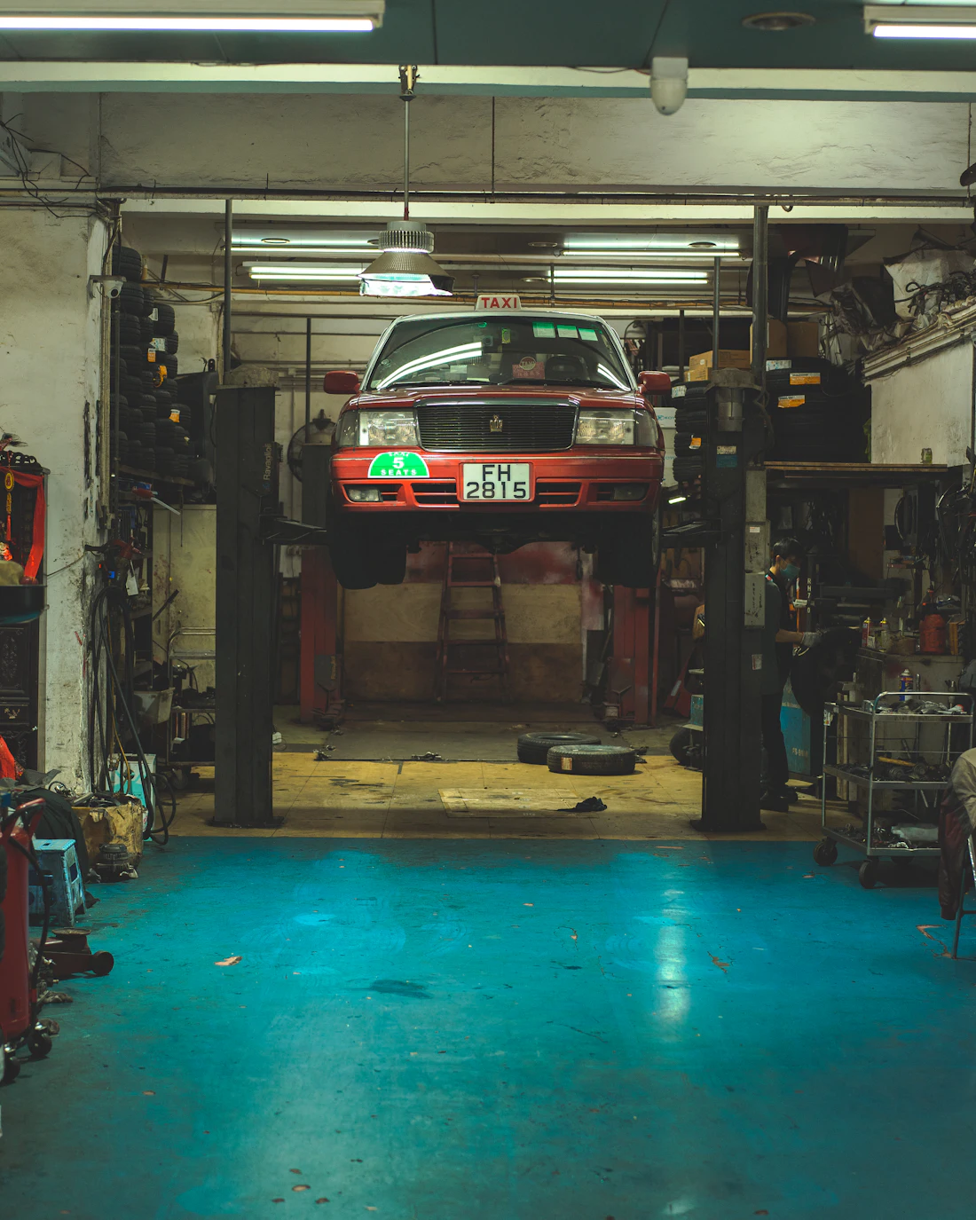 Vehicle raised on a two-post lift inside an auto repair shop
