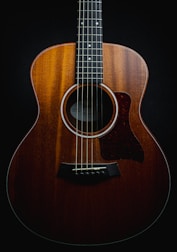 a close up of an acoustic guitar on a black background