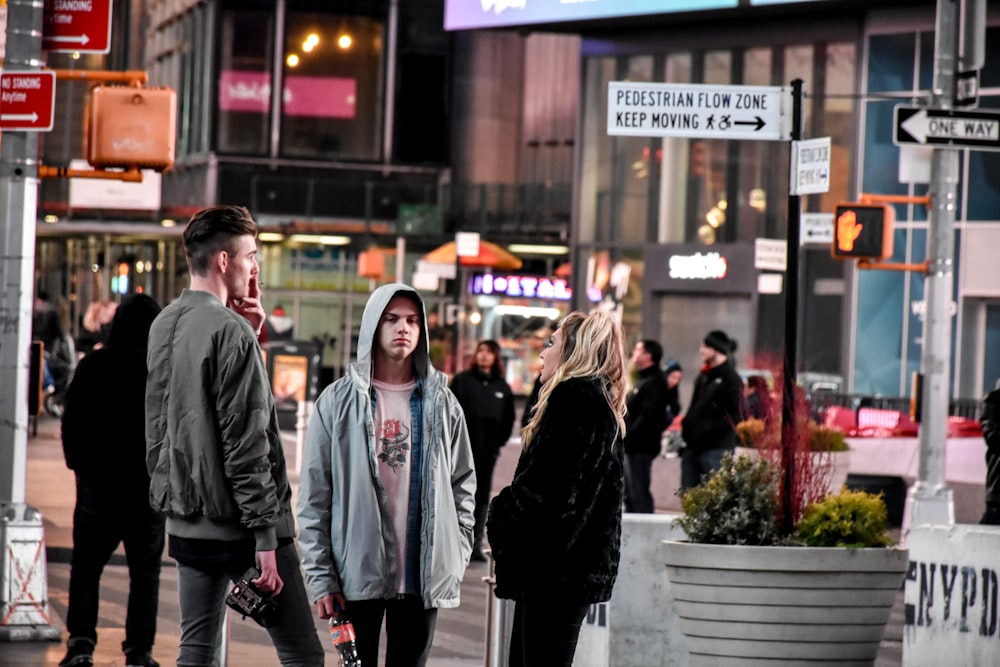 a group of people standing on a street corner