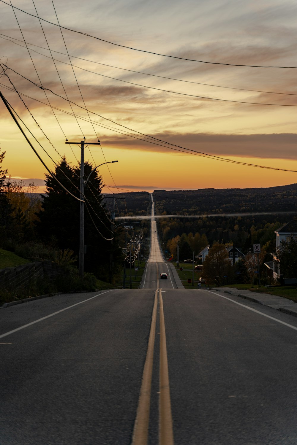 a long empty road with power lines above it