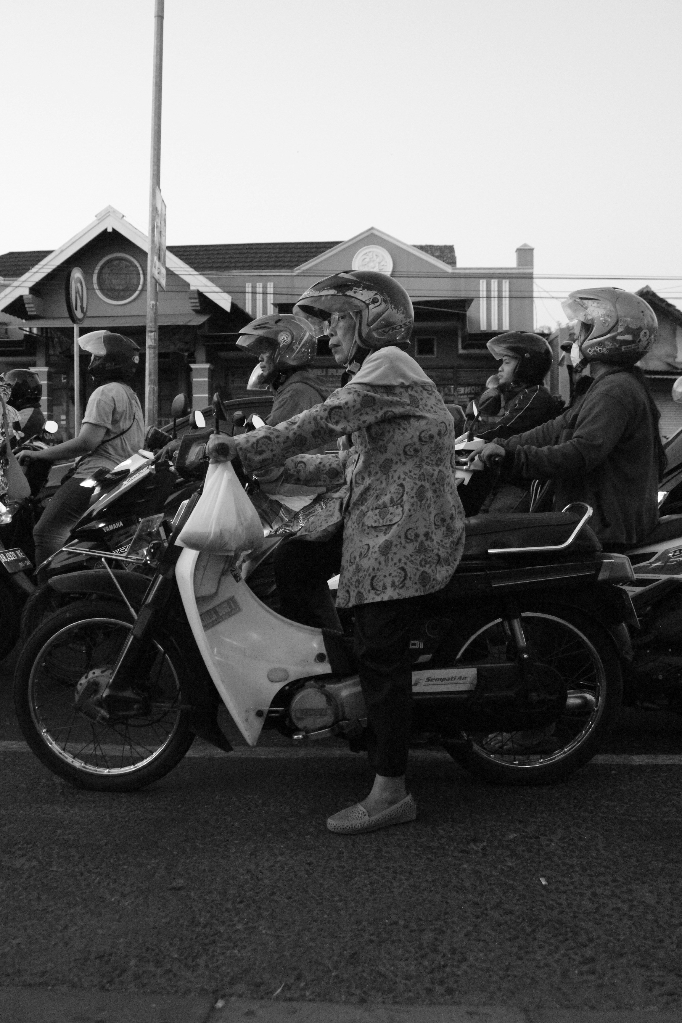 foto skala abu-abu pria dan wanita mengendarai sepeda motor