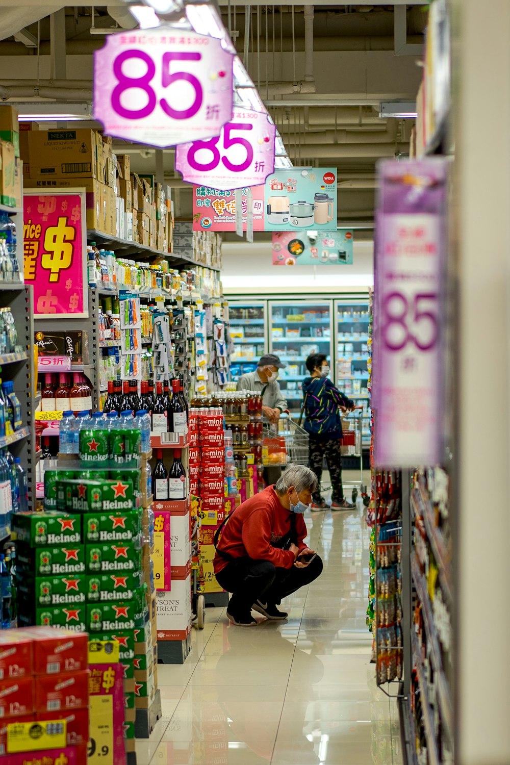 Femme en veste rouge debout près de caisses en plastique vert et blanc