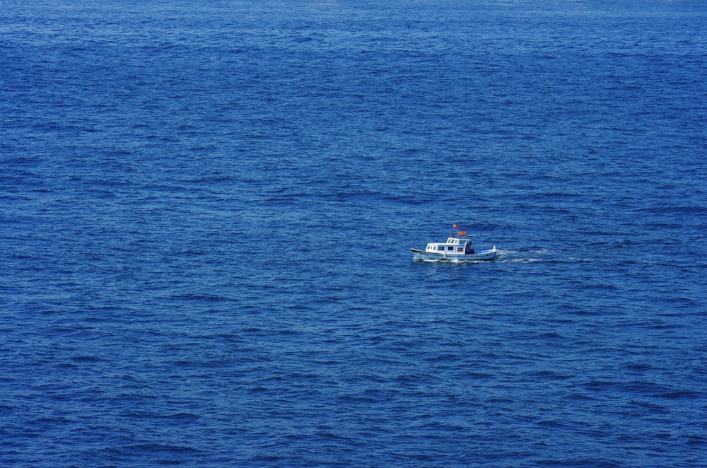 white and red boat on blue sea during daytime