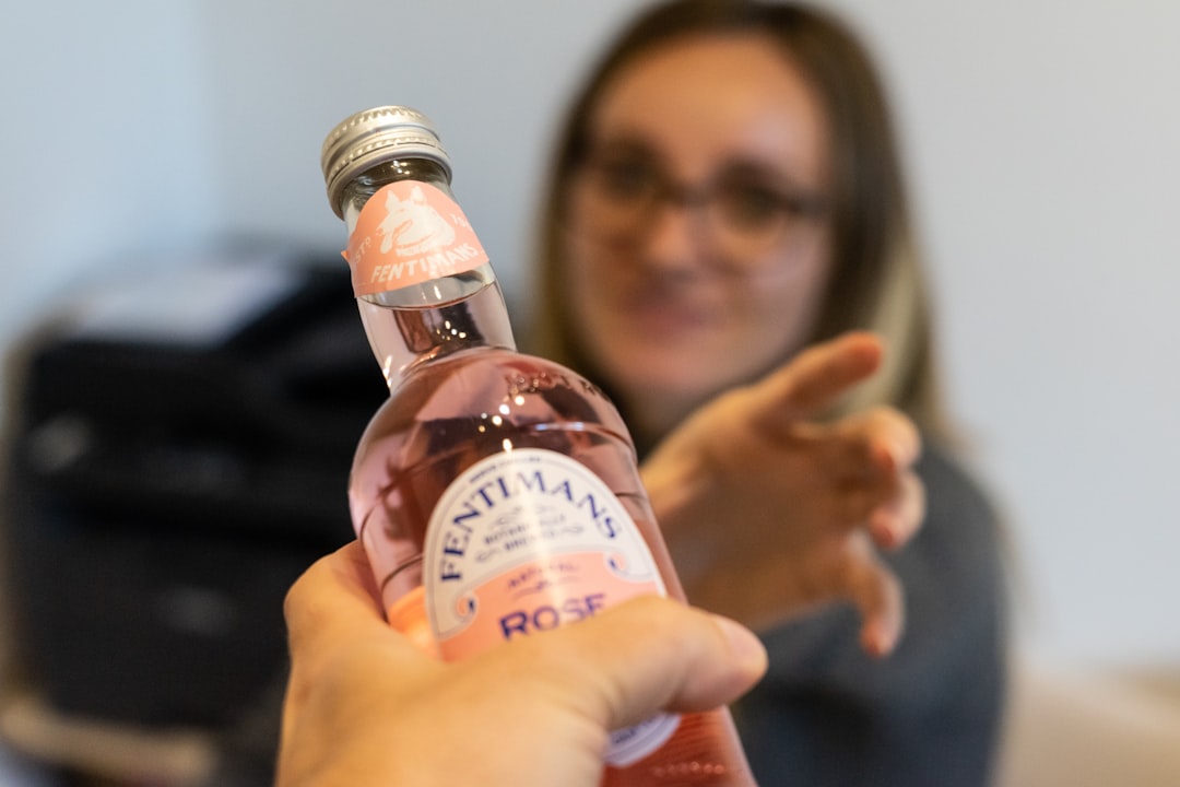 a woman holding a bottle of alcohol in her hand