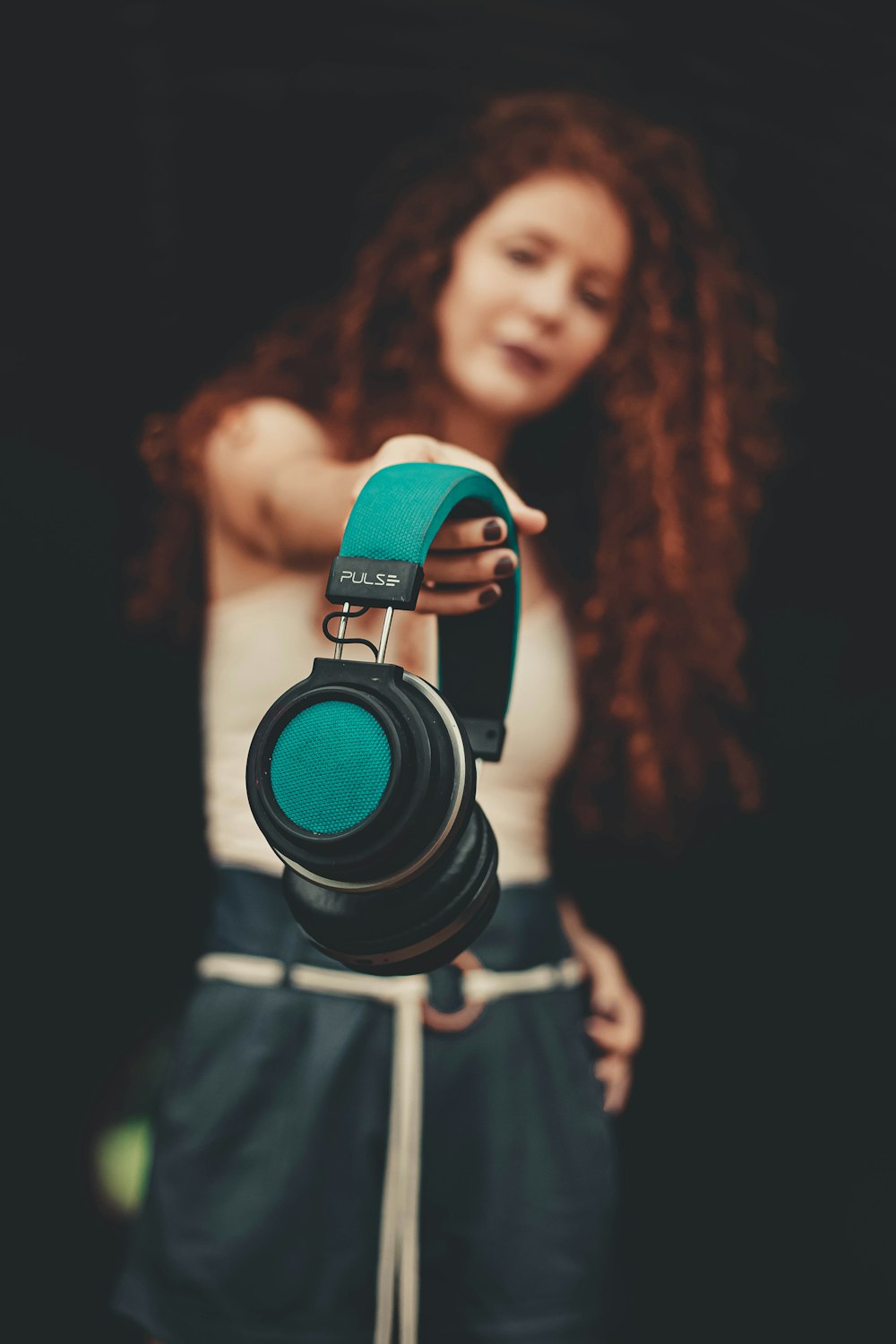 Frau in grünem Tanktop mit schwarzer und grüner DSLR-Kamera