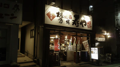 Warm, inviting interior of 麺彩華 bustling with happy customers enjoying their meals.