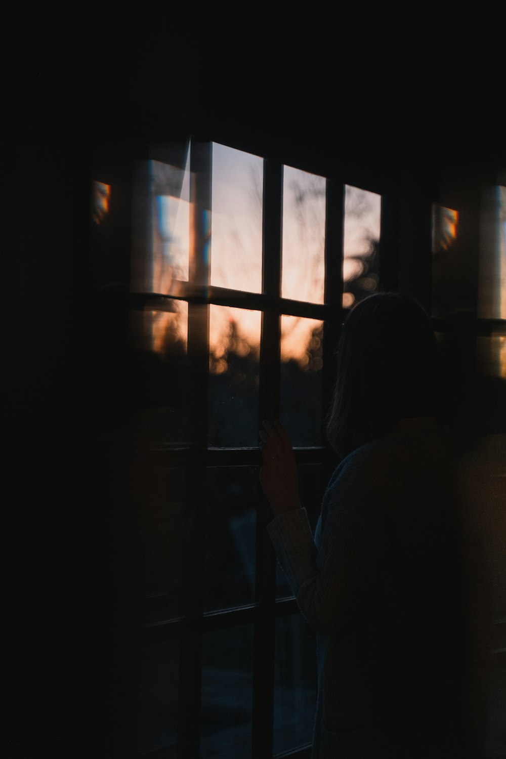 woman in white shirt standing near window