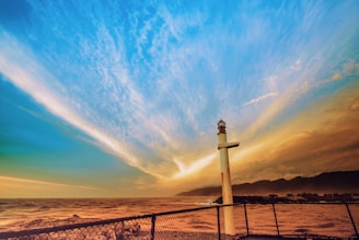 white and black lighthouse under blue sky during daytime