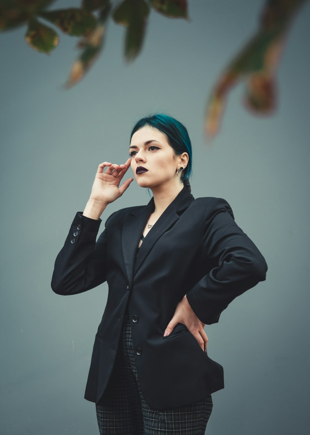 woman in black blazer holding her chin