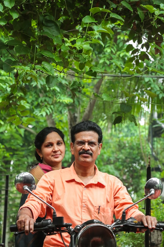 man in orange polo shirt standing beside man in orange polo shirt in Thrissur India